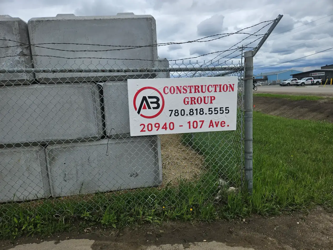 AB Construction Group sign on a chain-link fence