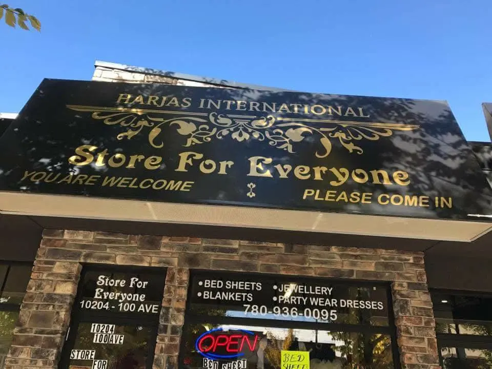 Harjas International black awning with gold lettering and ornament