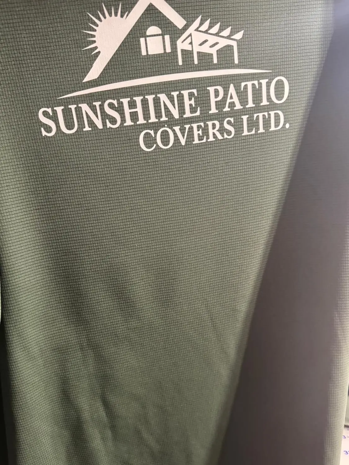 Green shirt with Sunshine Patio Covers logo in white