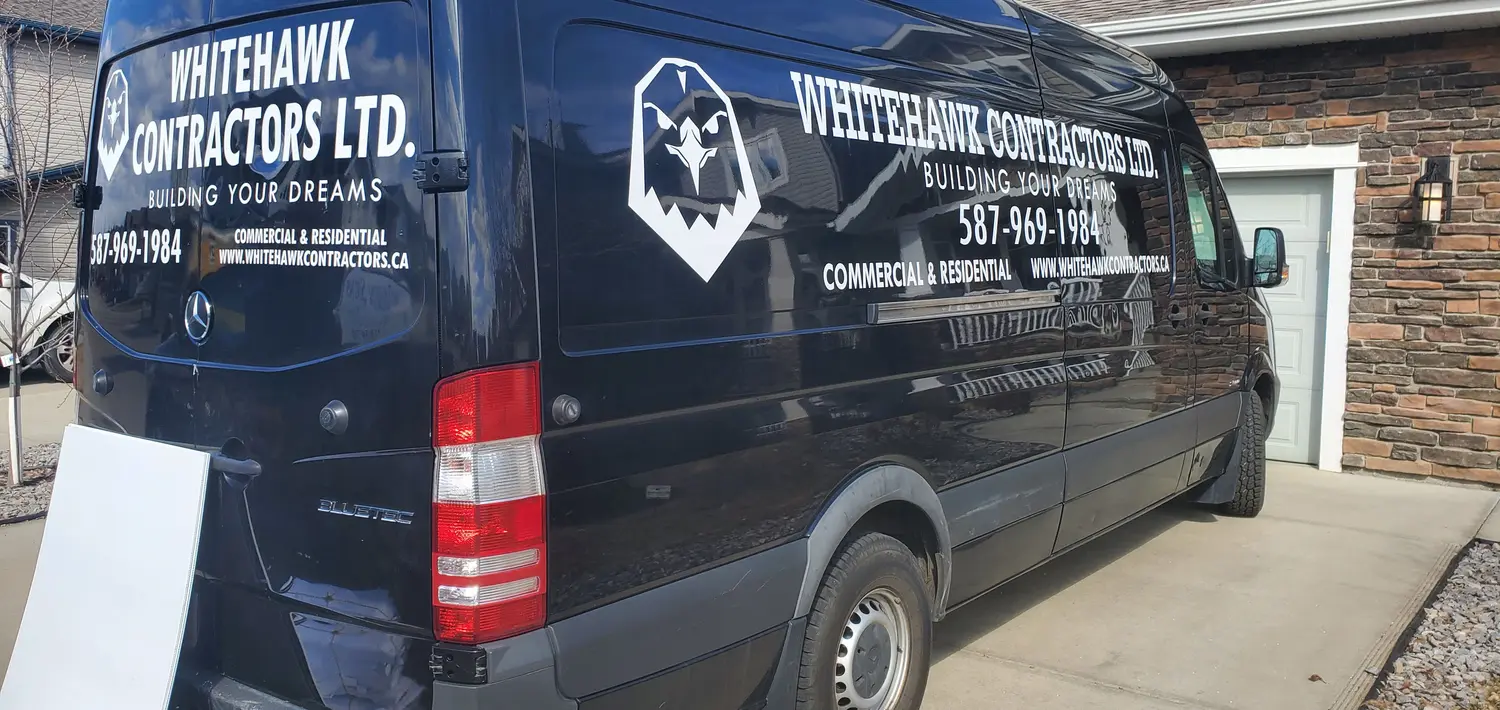 Whitehawk Contractors lettering on a black Sprinter van